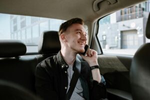een tevreden man is aan het bellen in de taxi - met taxi Panningen kun je genieten van de uitstekende service